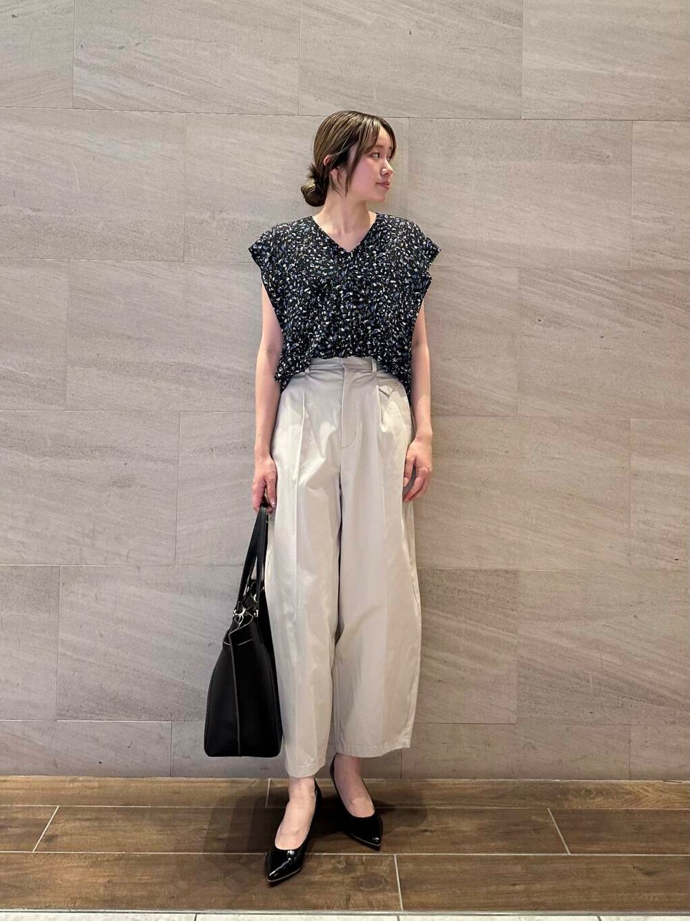 ブラック系のパンプス、ブラック系のシャツ/ブラウス、ベージュ系のその他パンツを着用したレディースの夏コーディネートの2枚目の写真