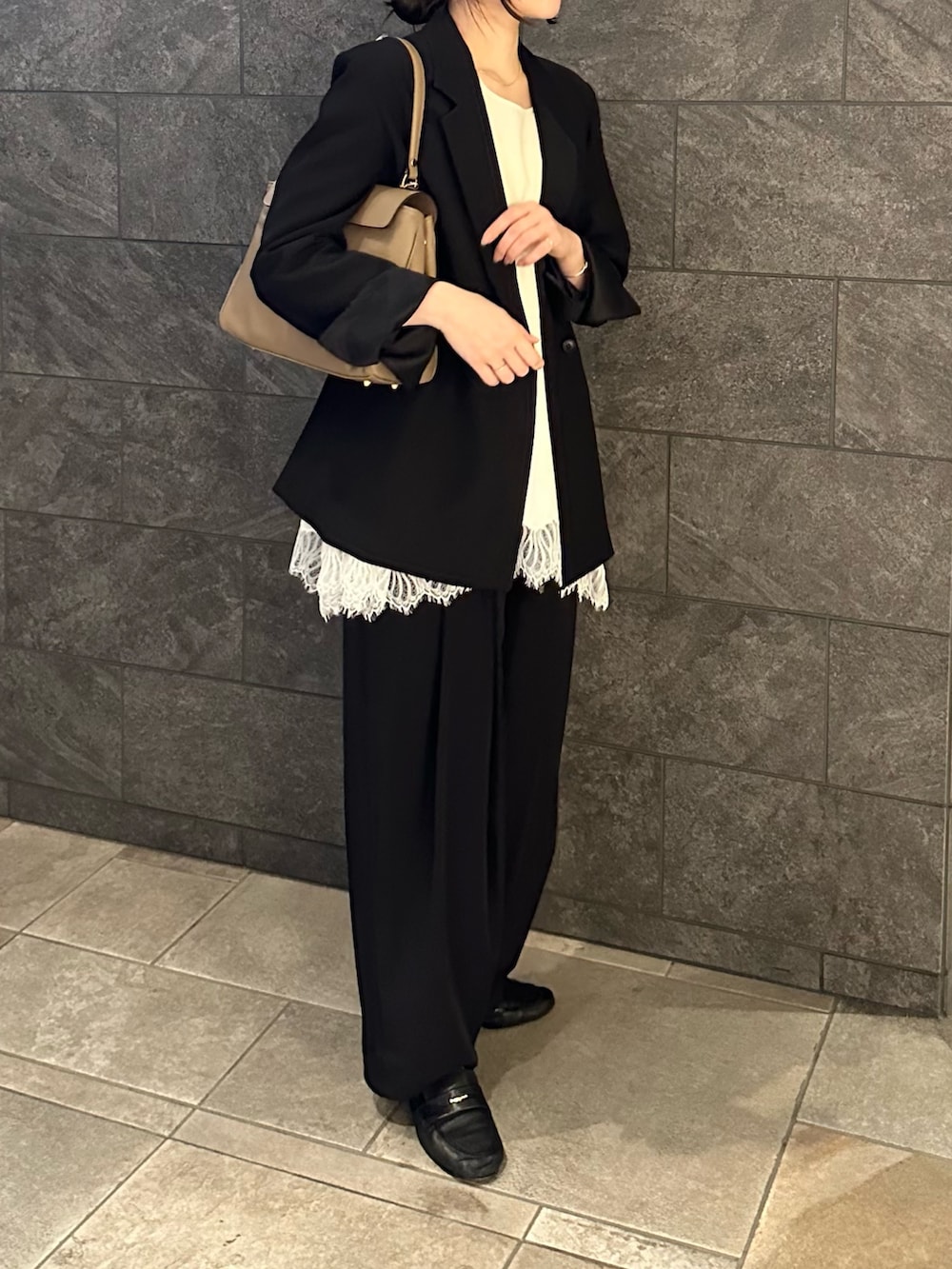 ベージュ系のハンドバッグ、ブラック系のその他パンツ、ホワイト系のタンクトップを着用したレディースの春コーディネートの3枚目の写真