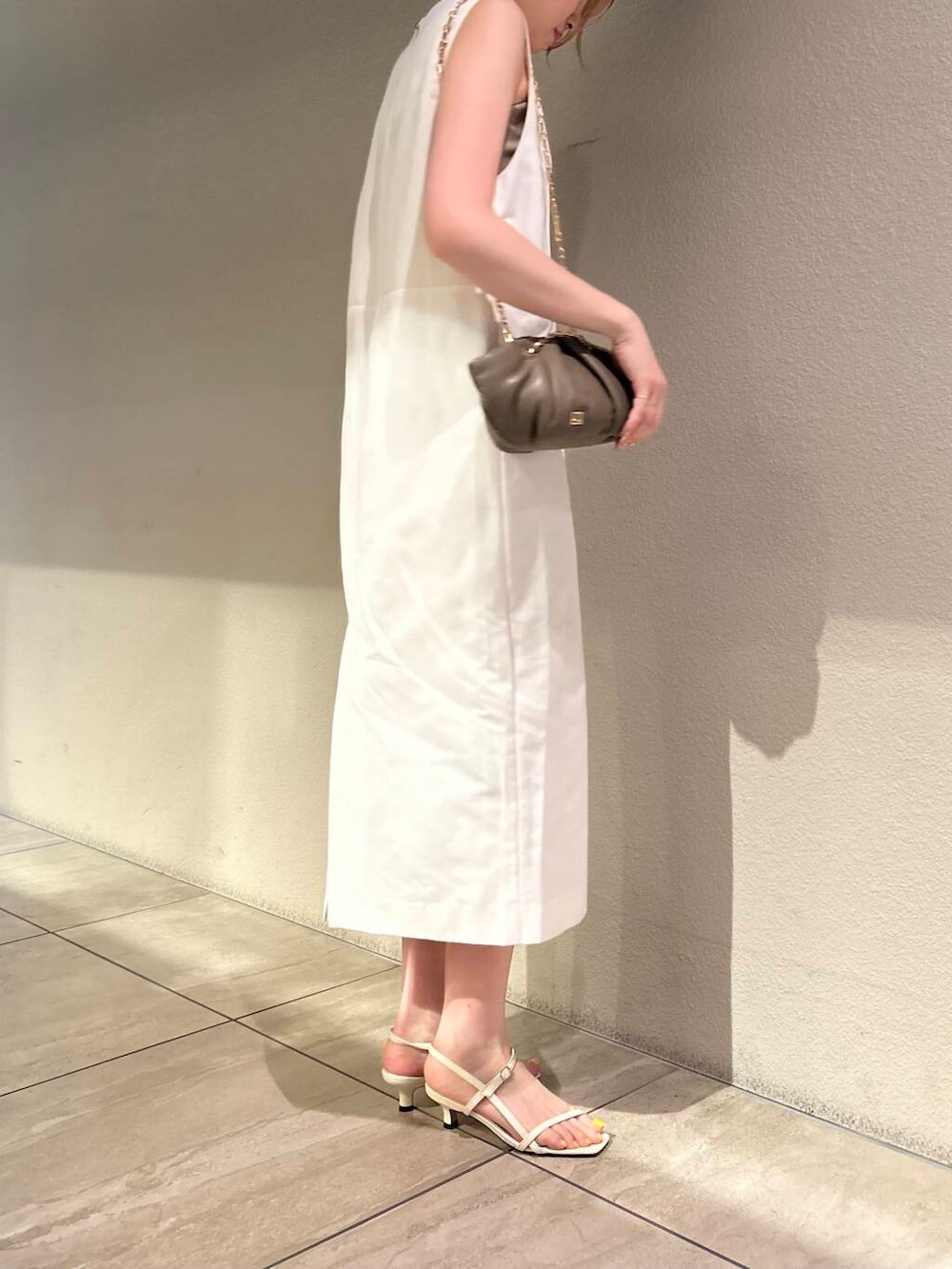 ホワイト系のサンダル、ホワイト系のワンピース、ベージュ系のキャミソールを着用したレディースの夏コーディネートの4枚目の写真