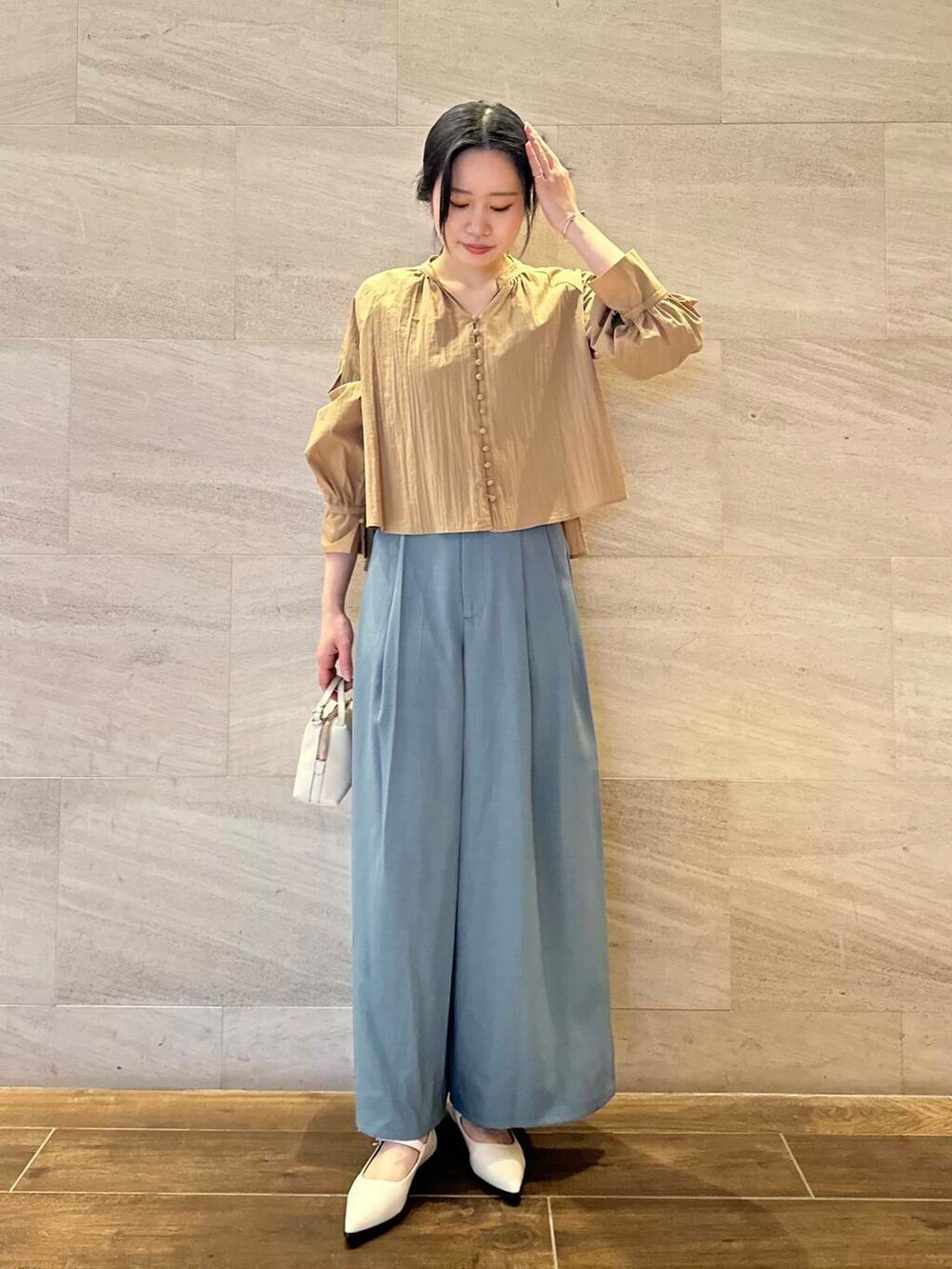 グレー系のトレンチコート、ブルー系のその他パンツ、イエロー系のシャツ/ブラウスを着用したレディースの春コーディネートの6枚目の写真