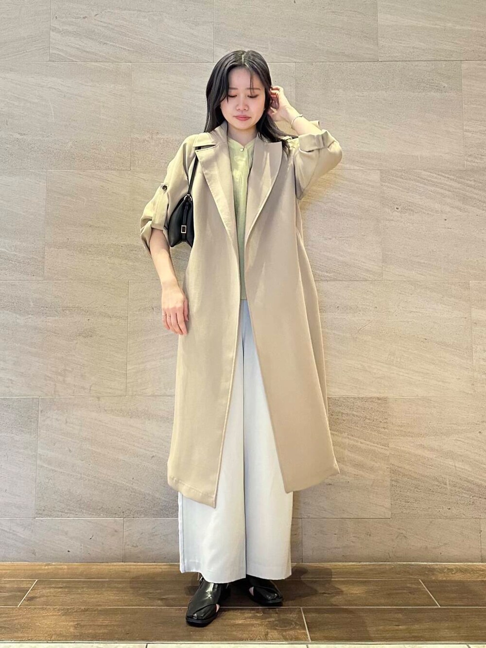 イエロー系のシャツ/ブラウス、ベージュ系のトレンチコート、ベージュ系のその他パンツを着用したレディースの春コーディネートの2枚目の写真