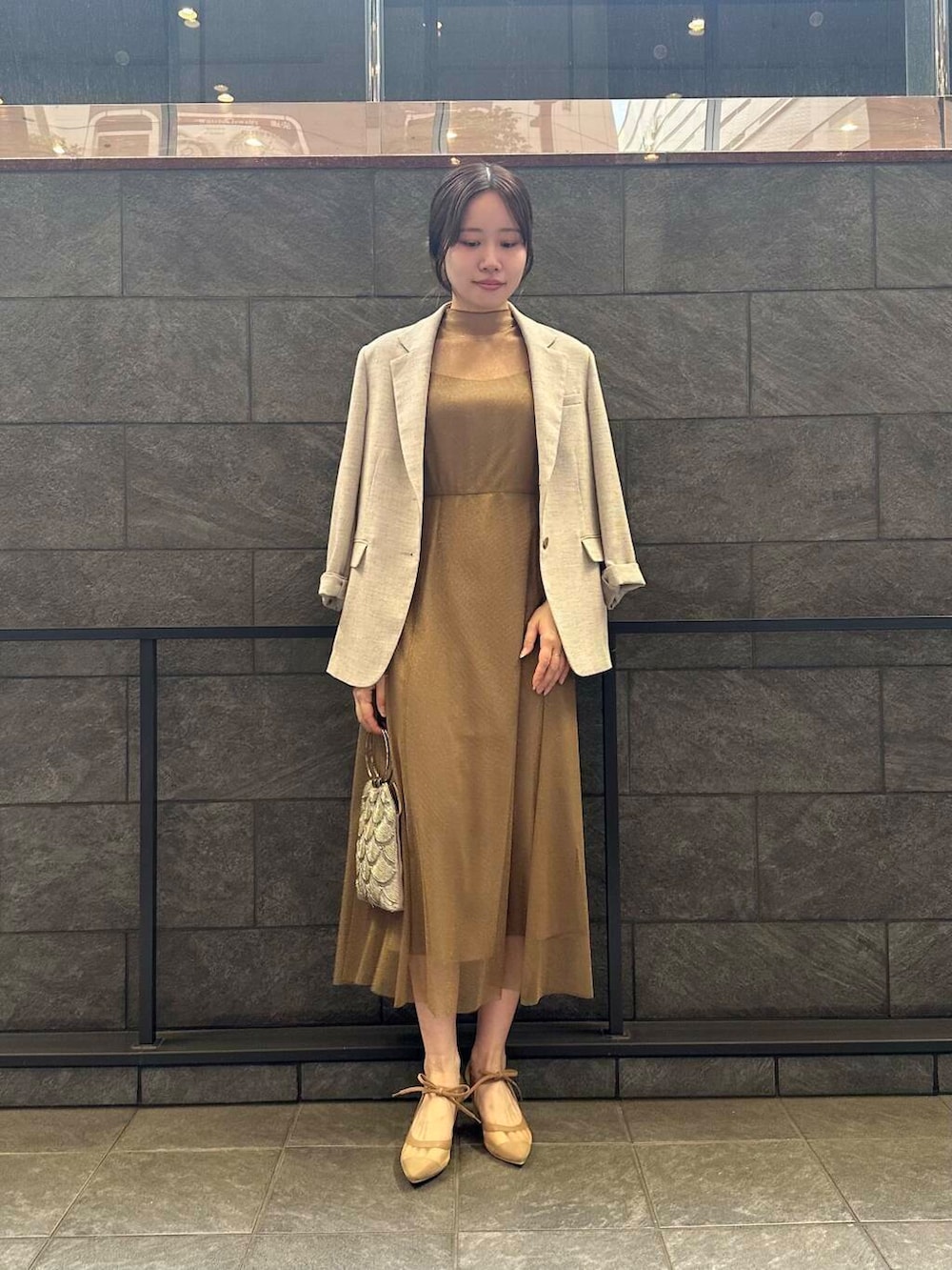 ゴールド系のワンピース、ベージュ系のハンドバッグ、ベージュ系のその他アウターを着用したレディースの夏コーディネートの3枚目の写真