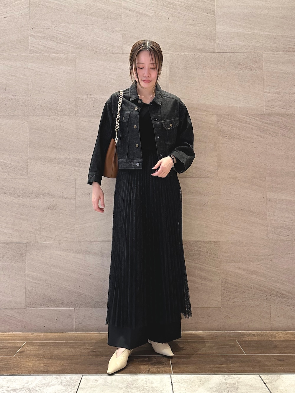 ブラック系のデニムジャケット、ホワイト系のTシャツ/カットソー、ブラック系のスカートを着用したレディースの秋コーディネートの2枚目の写真