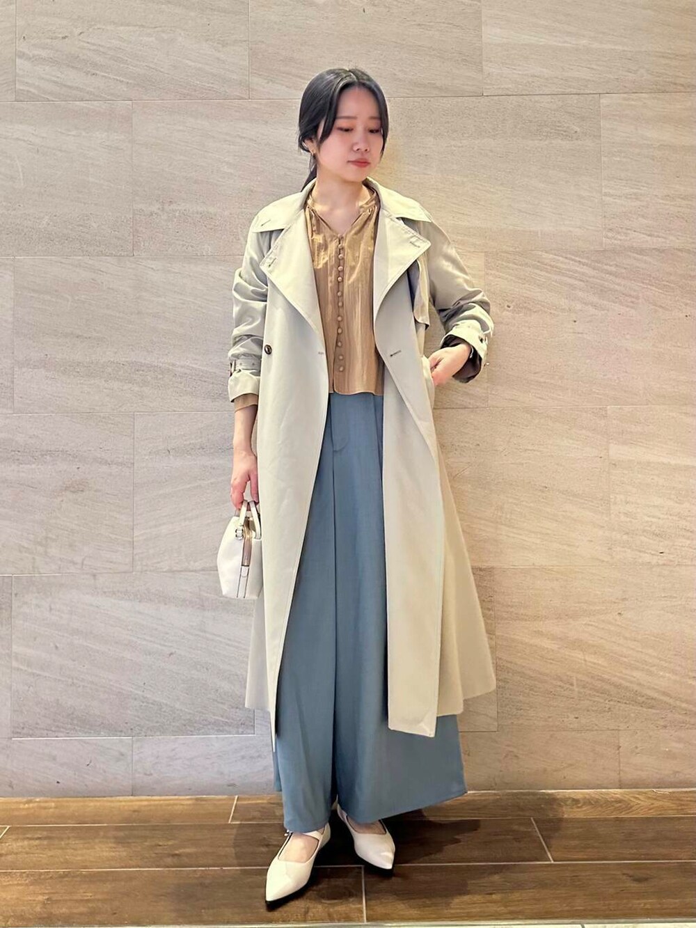 グレー系のトレンチコート、ブルー系のその他パンツ、イエロー系のシャツ/ブラウスを着用したレディースの春コーディネートの2枚目の写真