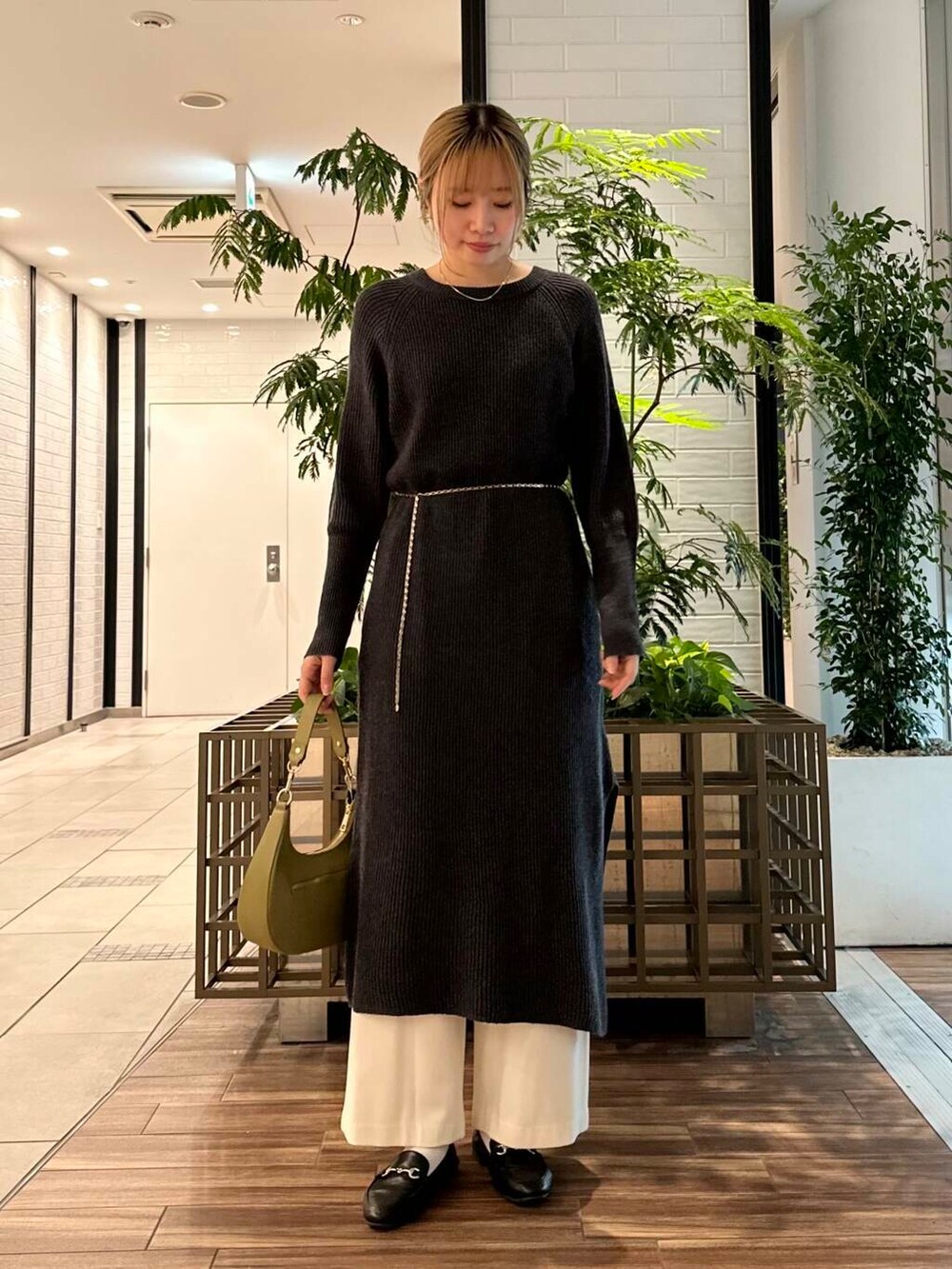 グリーン系のショルダーバッグ、グレー系のワンピース、ホワイト系のその他パンツを着用したレディースの冬コーディネートの3枚目の写真