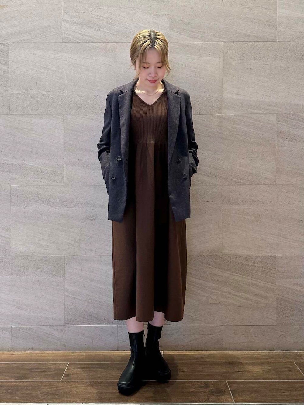 ブラック系のブーツ、ブルー系のその他アウター、ブラウン系のワンピースを着用したレディースの冬コーディネートの3枚目の写真