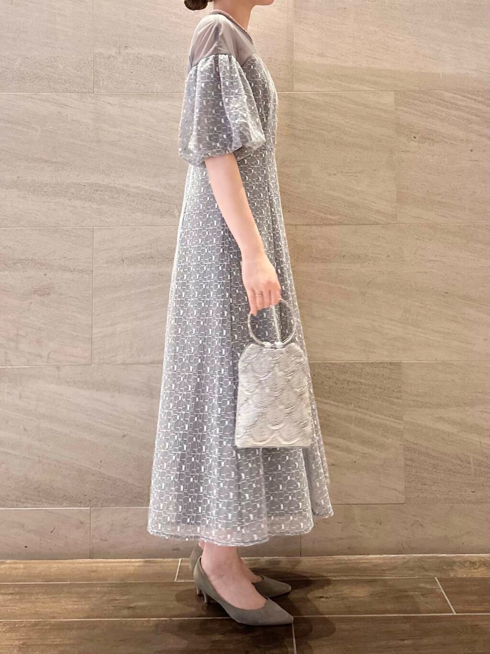 ブラウン系のパンプス、シルバー系のハンドバッグ、グレー系のワンピースを着用したレディースの春コーディネートの4枚目の写真