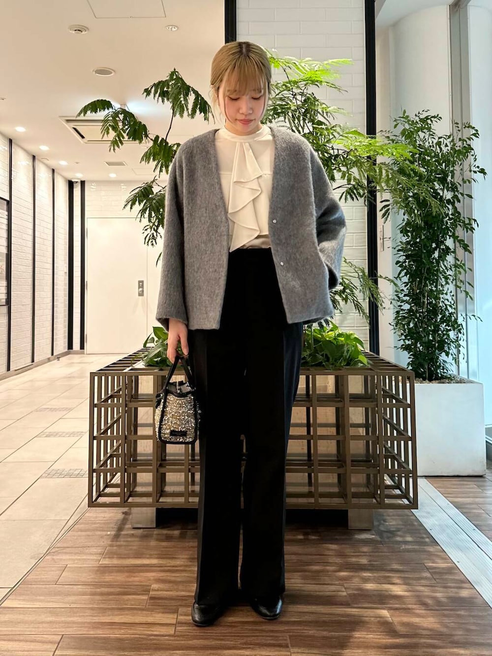 ブラック系のその他パンツ、ホワイト系のシャツ/ブラウス、グレー系のノーカラージャケットを着用したレディースの冬コーディネートの3枚目の写真