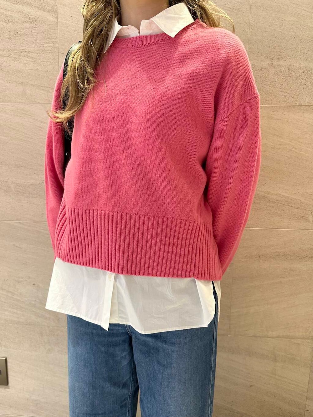 ピンク系のニット/セーター、ホワイト系のシャツ/ブラウス、ブラック系のショルダーバッグを着用したレディースの冬コーディネートの5枚目の写真