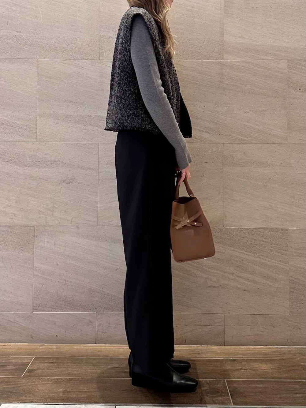 ブラウン系のハンドバッグ、グレー系のニット/セーター、ブラック系のその他パンツを着用したレディースの冬コーディネートの5枚目の写真