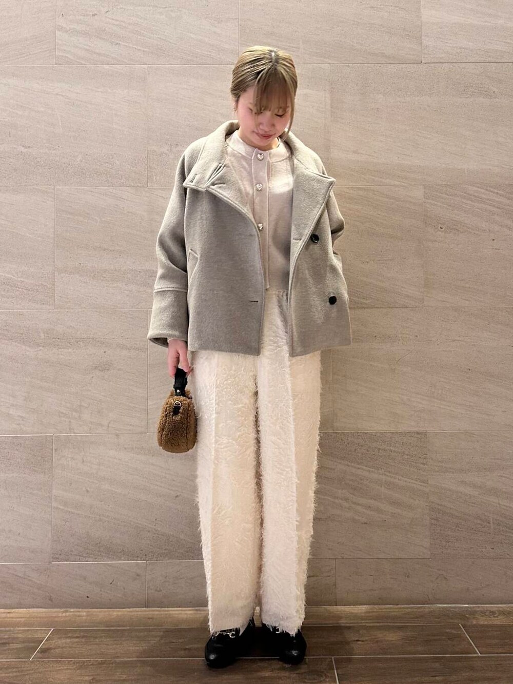 ブラウン系のピーコート、ホワイト系のその他パンツ、ホワイト系のカーディガン/ボレロを着用したレディースの冬コーディネートの2枚目の写真