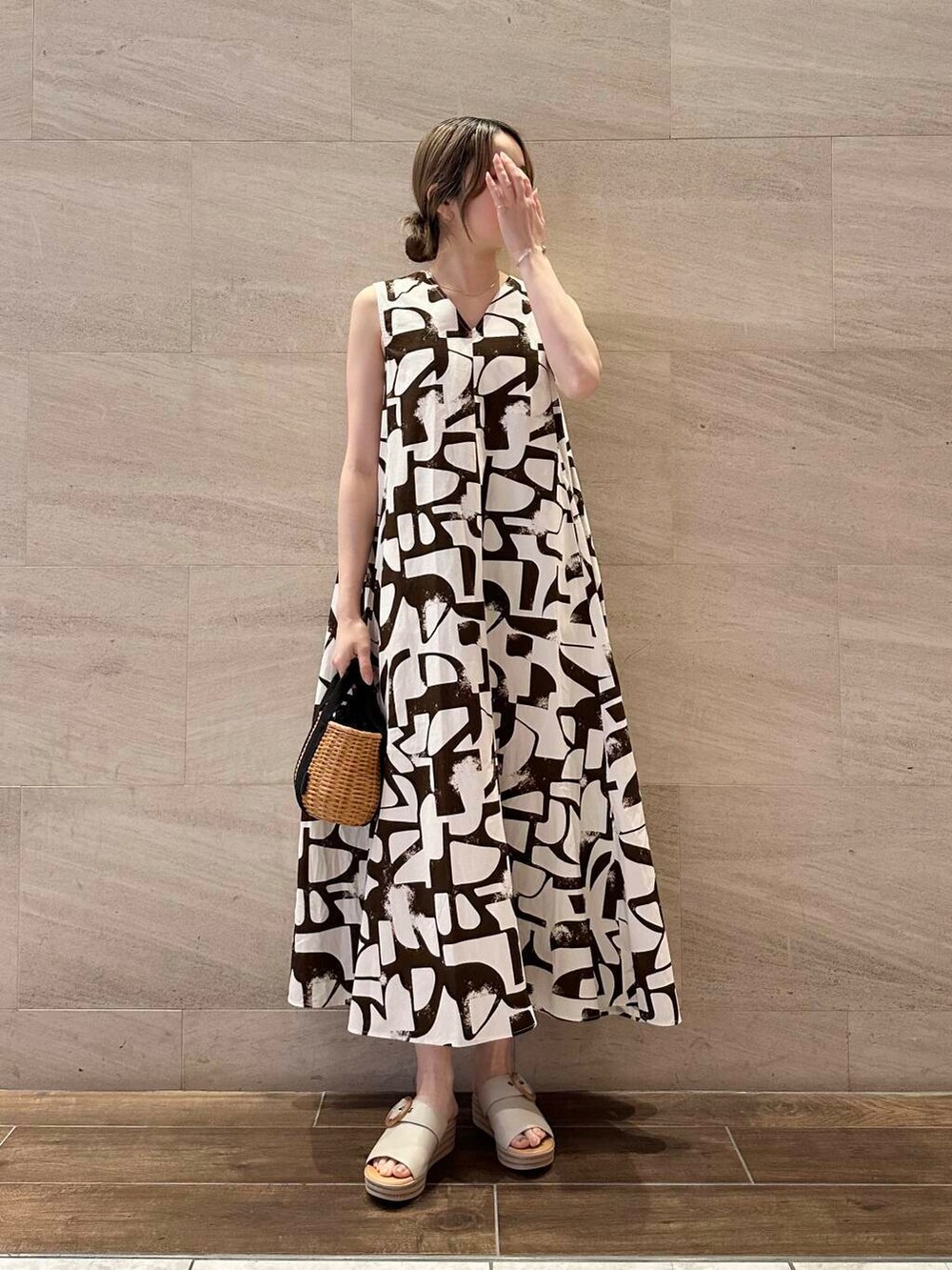 ブラック系のハンドバッグ、ブラック系のカーディガン/ボレロ、ブラウン系のワンピースを着用したレディースの春コーディネートの4枚目の写真