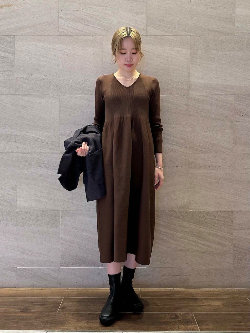 ブラック系のブーツ、ブルー系のその他アウター、ブラウン系のワンピースを着用したレディースの冬コーディネートの4枚目の写真