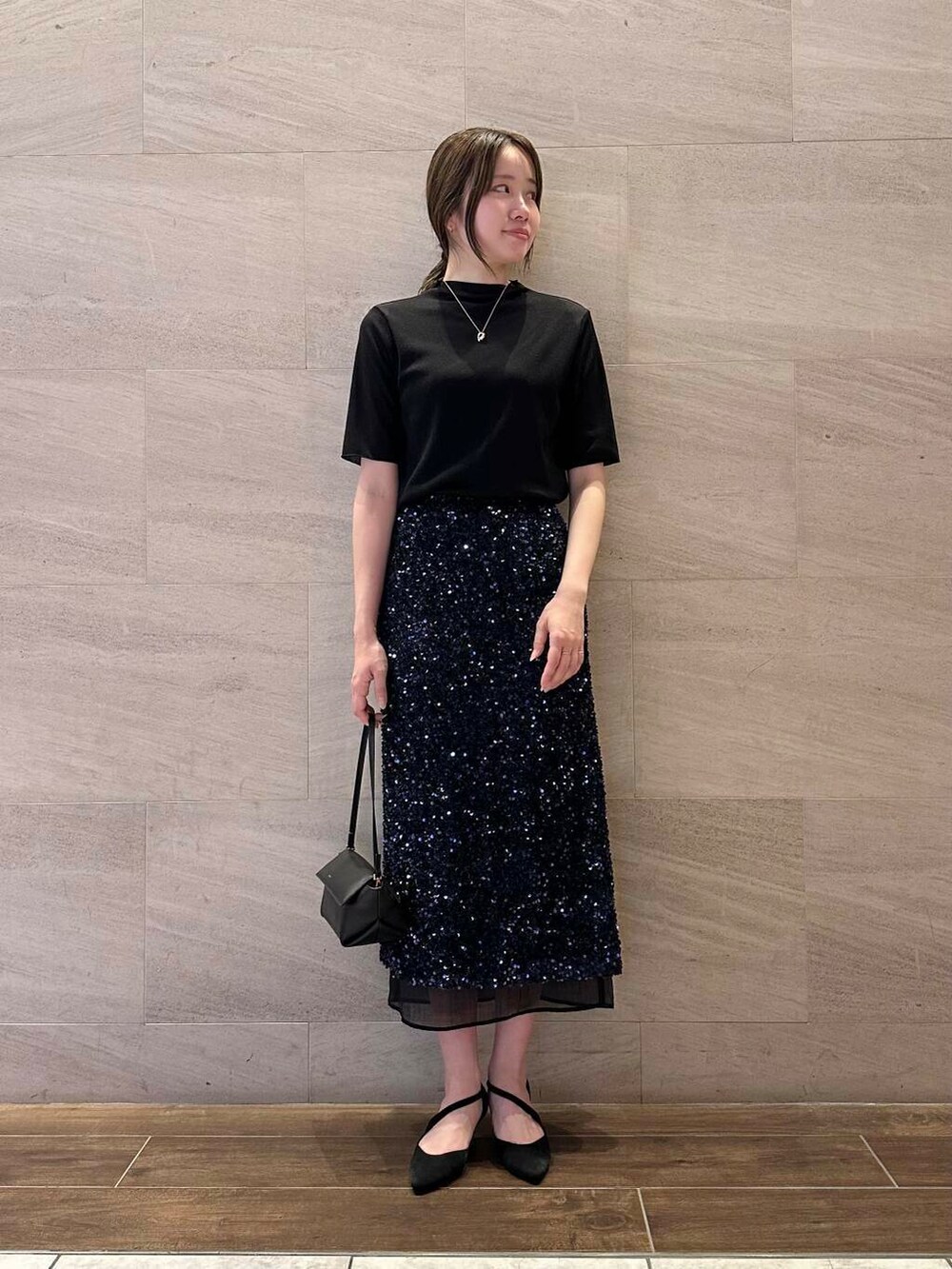 ブルー系のスカート、ブラック系のTシャツ/カットソー、シルバー系のネックレスを着用したレディースの夏コーディネートの3枚目の写真