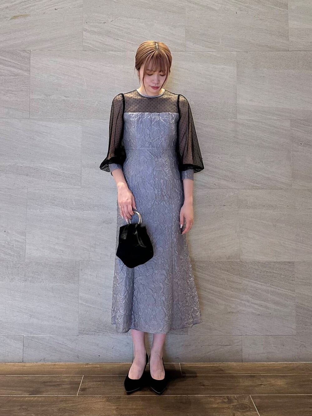 ブラック系のパンプス、ブラック系のハンドバッグ、グレー系のワンピースを着用したレディースの夏コーディネートの3枚目の写真