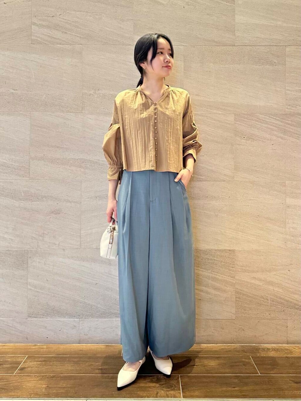 グレー系のトレンチコート、ブルー系のその他パンツ、イエロー系のシャツ/ブラウスを着用したレディースの春コーディネートの5枚目の写真