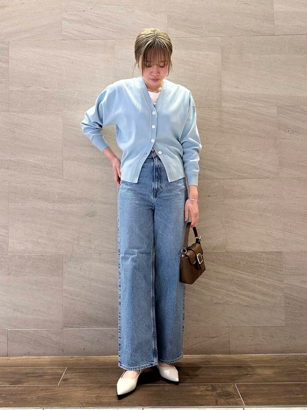 ブルー系のカーディガン/ボレロ、ブルー系のデニムパンツ、ブラウン系のショルダーバッグを着用したレディースの冬コーディネートの3枚目の写真