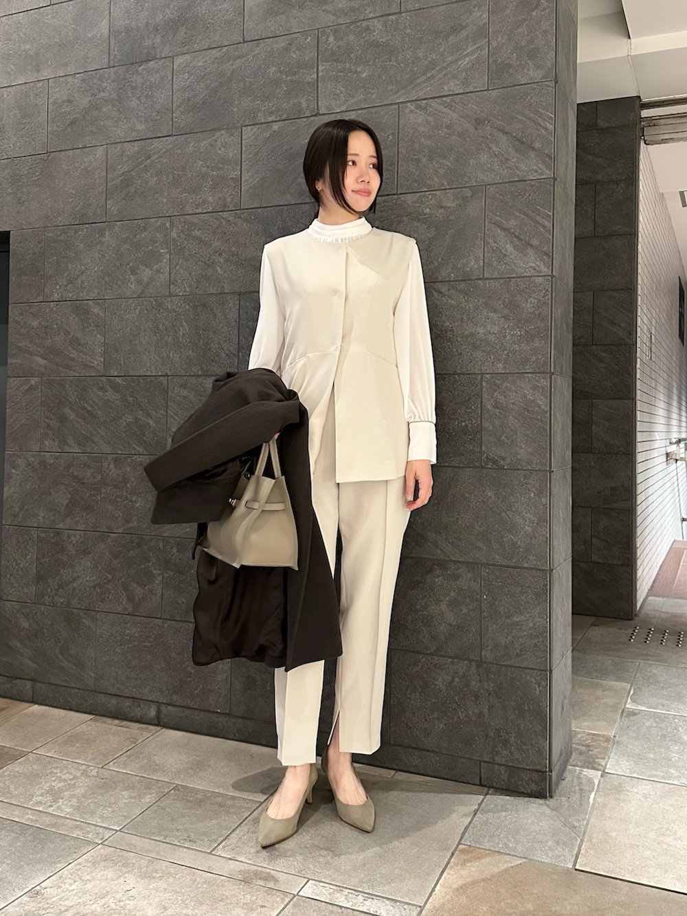 ホワイト系のセットアップ、ベージュ系のトートバッグ、ブラウン系のその他アウターを着用したレディースの冬コーディネートの4枚目の写真