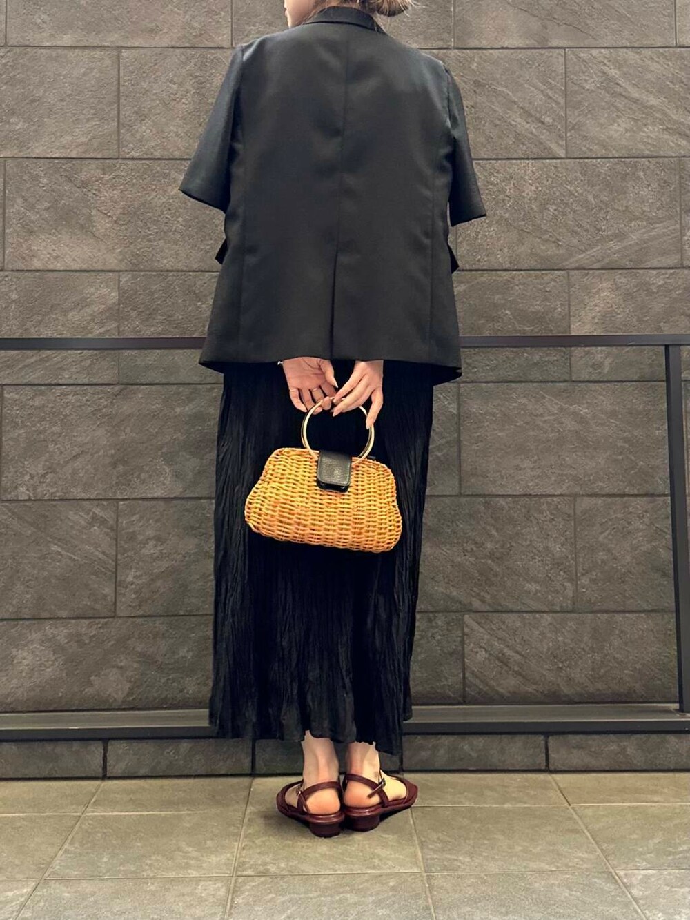 レッド系のサンダル、ブラック系のワンピース、ブラック系のその他アウターを着用したレディースの春コーディネートの4枚目の写真