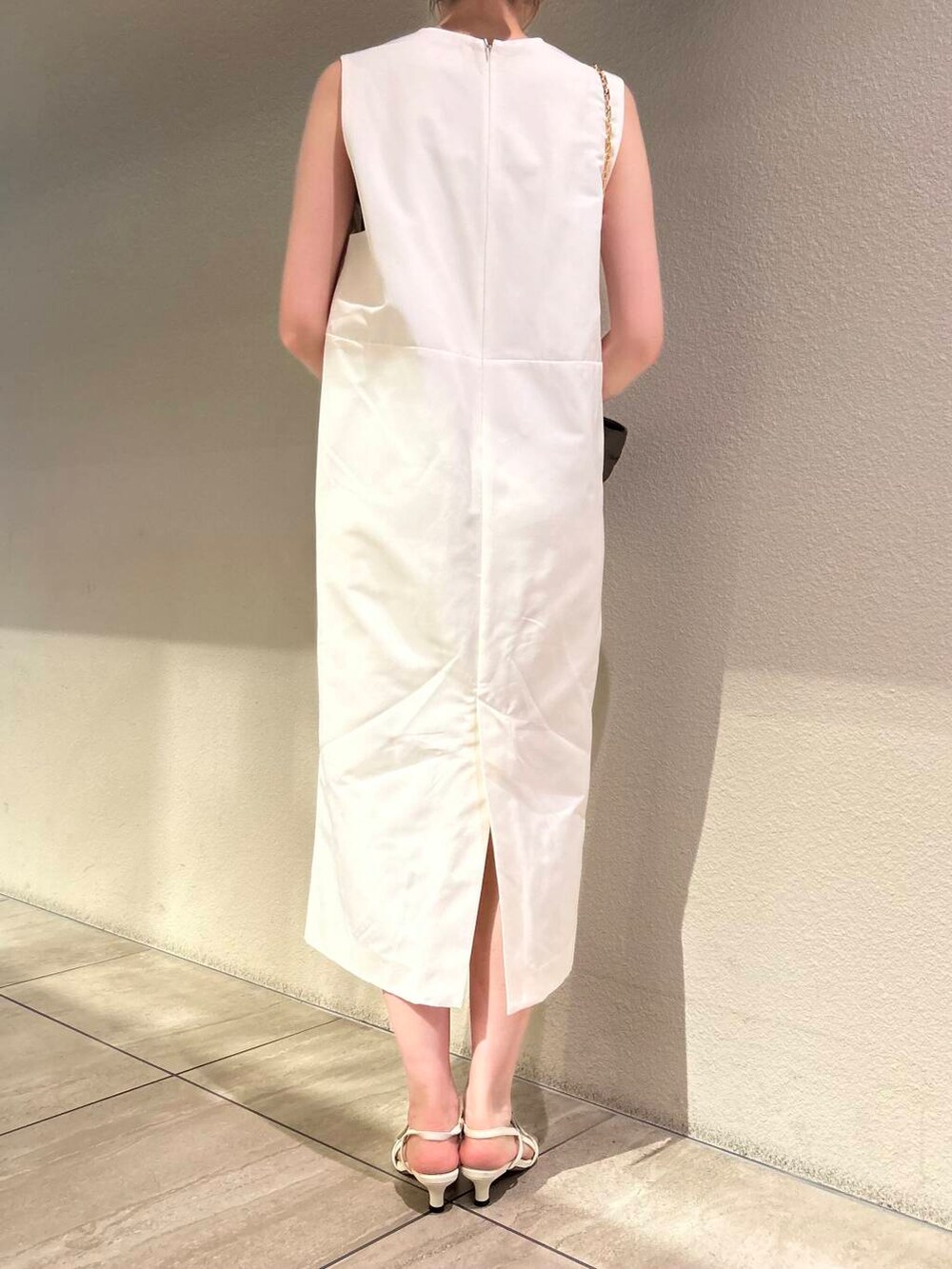 ホワイト系のサンダル、ホワイト系のワンピース、ベージュ系のキャミソールを着用したレディースの夏コーディネートの5枚目の写真