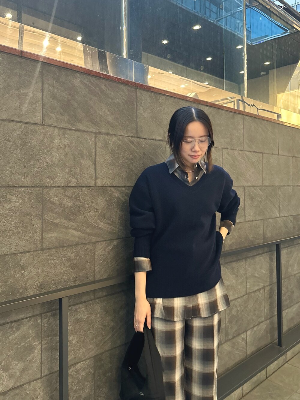 ブラック系のハンドバッグ、ブルー系のシャツ/ブラウス、ブルー系のスラックスを着用したレディースの秋コーディネートの2枚目の写真