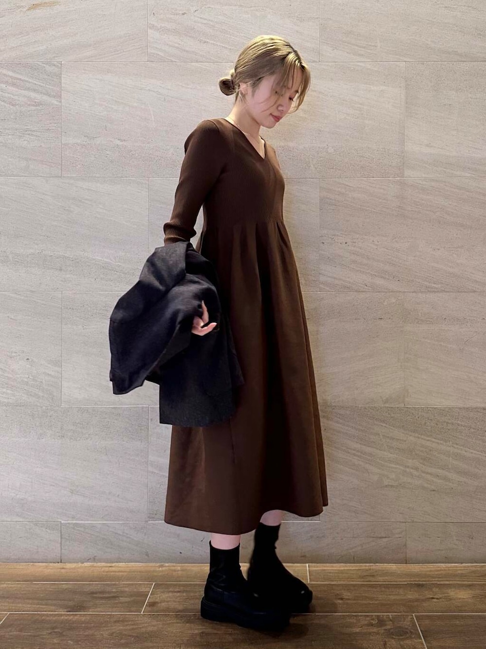 ブラック系のブーツ、ブルー系のその他アウター、ブラウン系のワンピースを着用したレディースの冬コーディネートの6枚目の写真