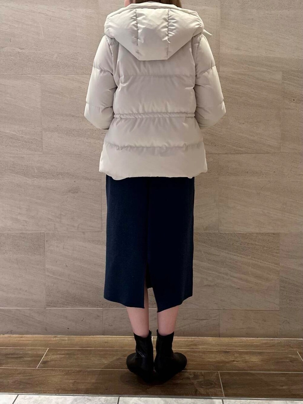 ブラック系のブーツ、ホワイト系のダウンジャケット/コート、ブルー系のワンピースを着用したレディースの冬コーディネートの5枚目の写真