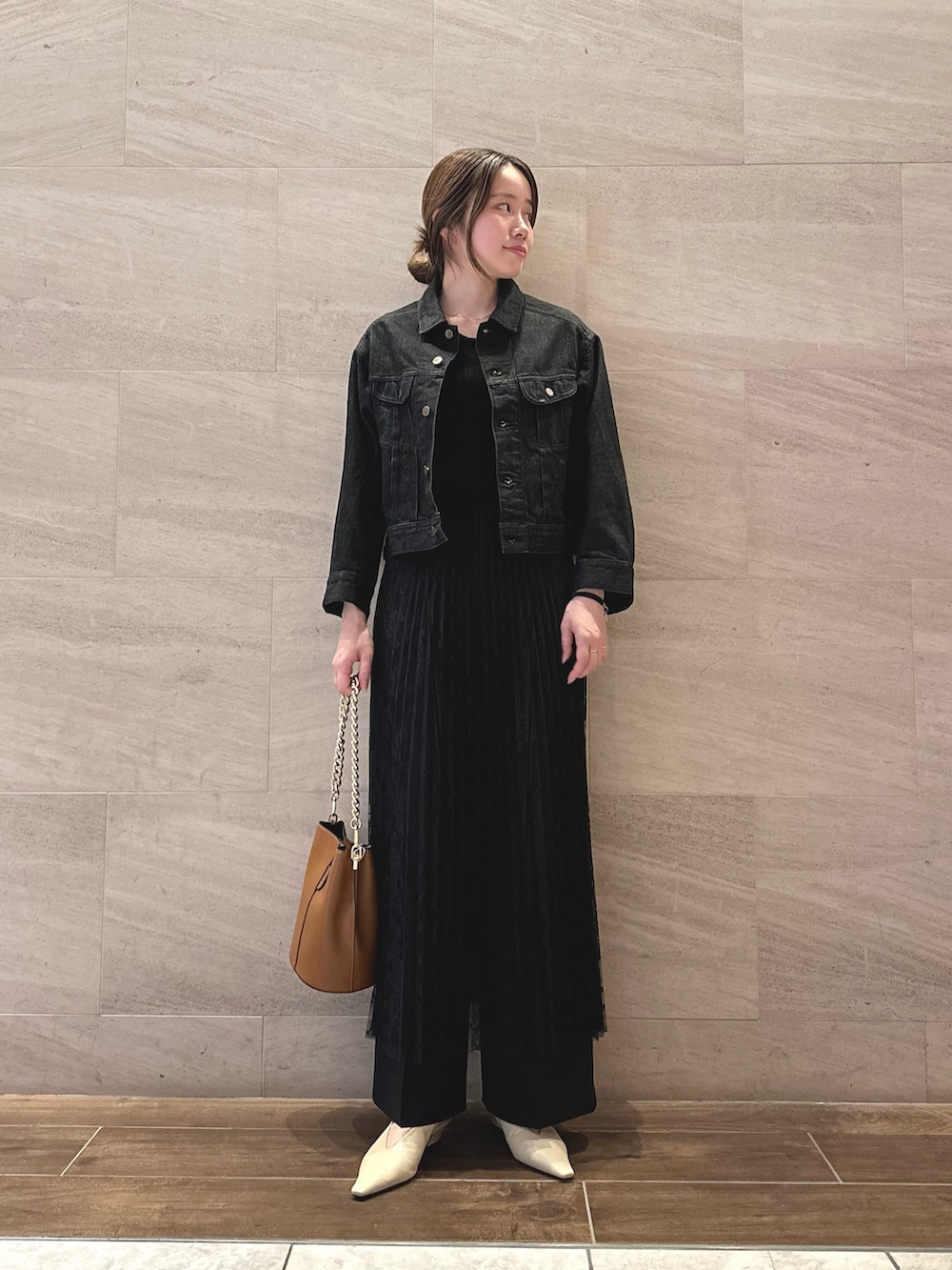 ブラック系のデニムジャケット、ホワイト系のTシャツ/カットソー、ブラック系のスカートを着用したレディースの秋コーディネートの3枚目の写真