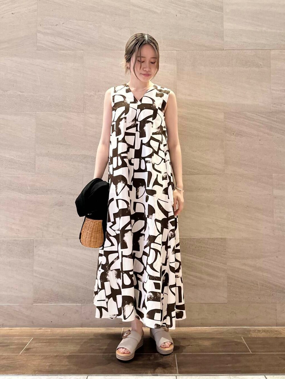 ブラック系のハンドバッグ、ブラック系のカーディガン/ボレロ、ブラウン系のワンピースを着用したレディースの春コーディネートの3枚目の写真