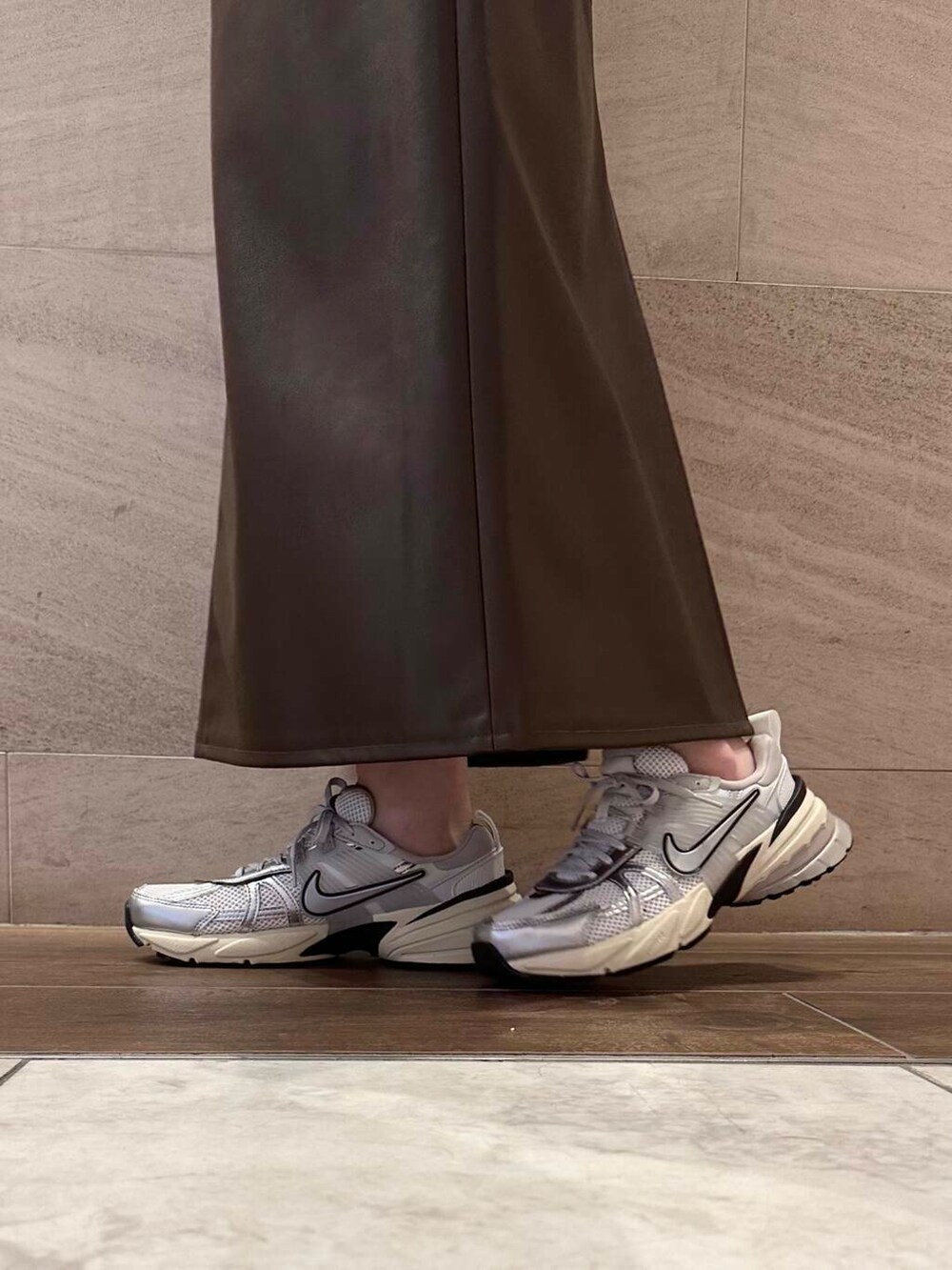 ブラウン系のスカート、イエロー系のダウンジャケット/コート、ホワイト系のスニーカーを着用したレディースの冬コーディネートの6枚目の写真