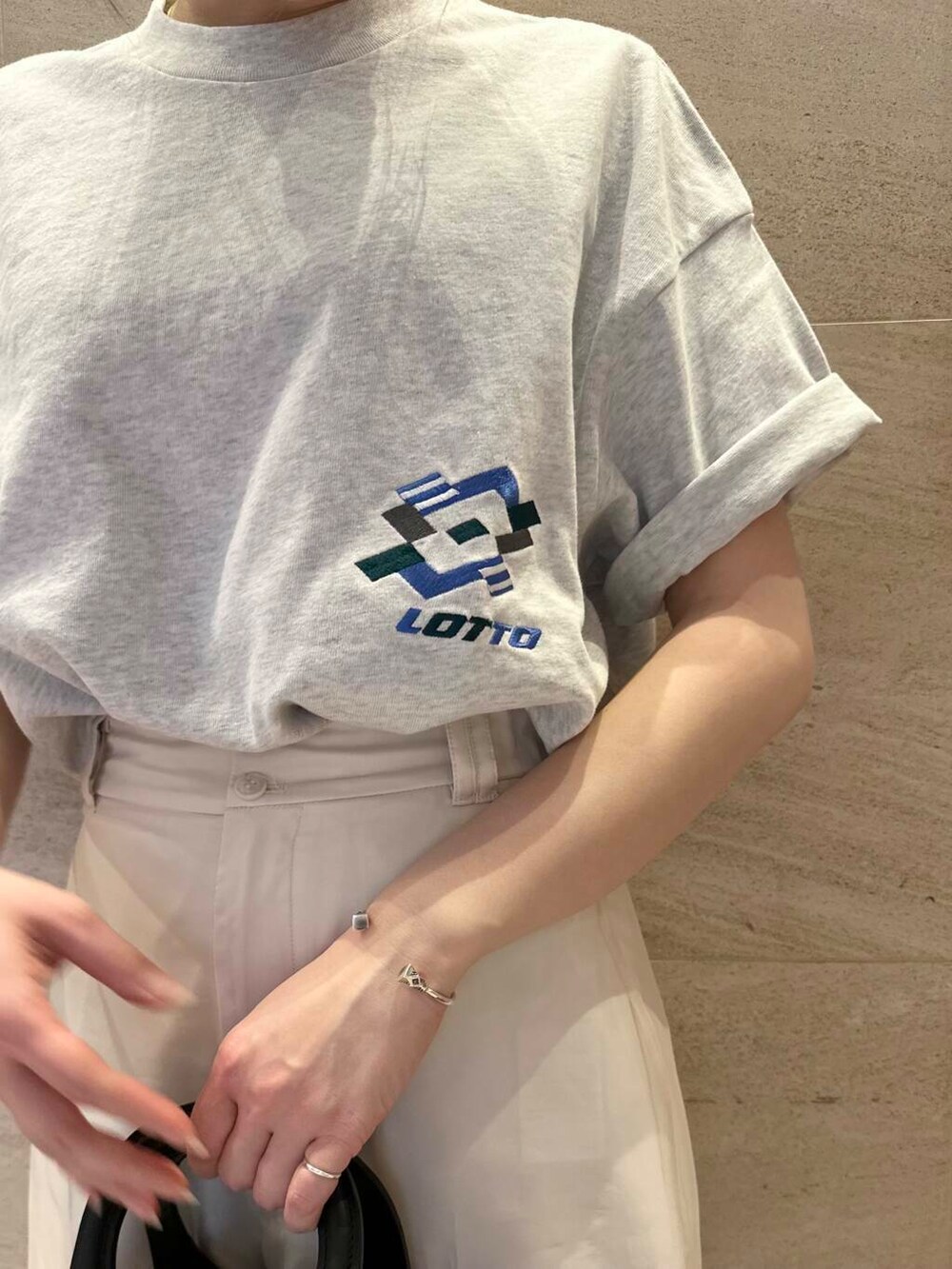 ベージュ系のショルダーバッグ、ホワイト系のその他パンツ、グレー系のTシャツ/カットソーを着用したレディースの春コーディネートの5枚目の写真