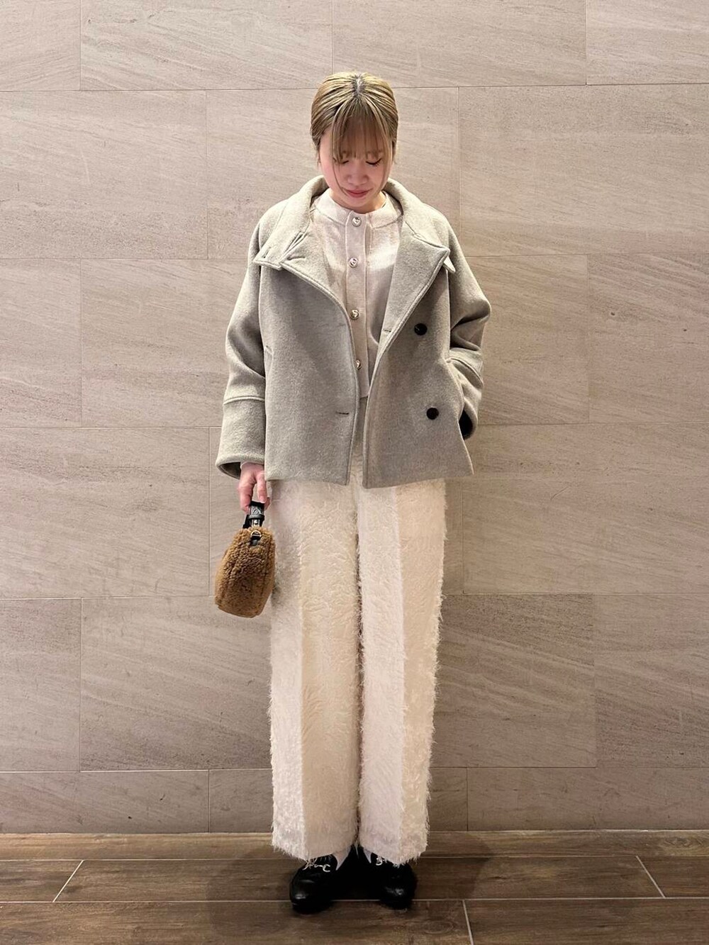 ブラウン系のピーコート、ホワイト系のその他パンツ、ホワイト系のカーディガン/ボレロを着用したレディースの冬コーディネートの5枚目の写真