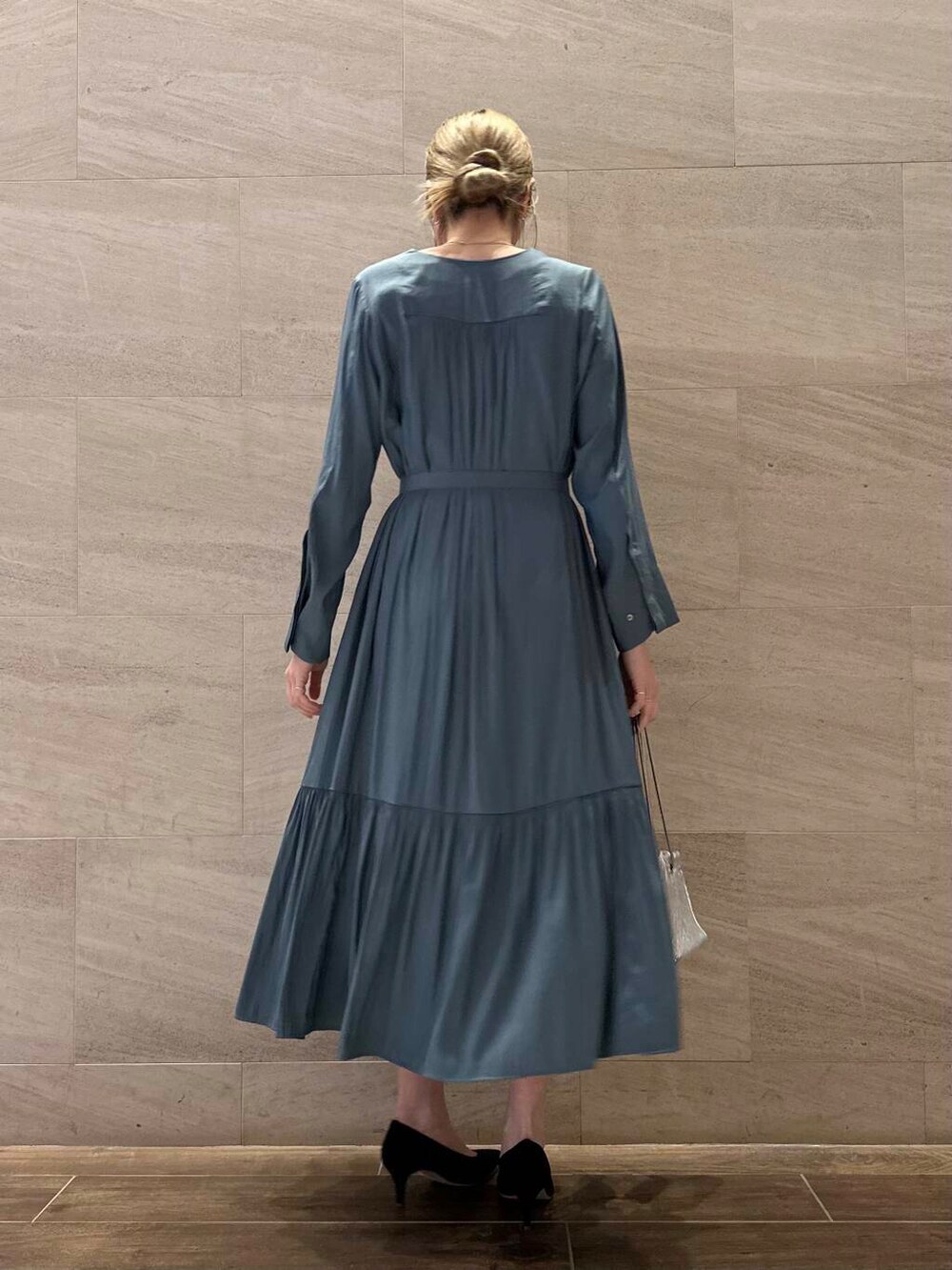 ブラック系のパンプス、ブルー系のワンピース、シルバー系のショルダーバッグを着用したレディースの冬コーディネートの6枚目の写真