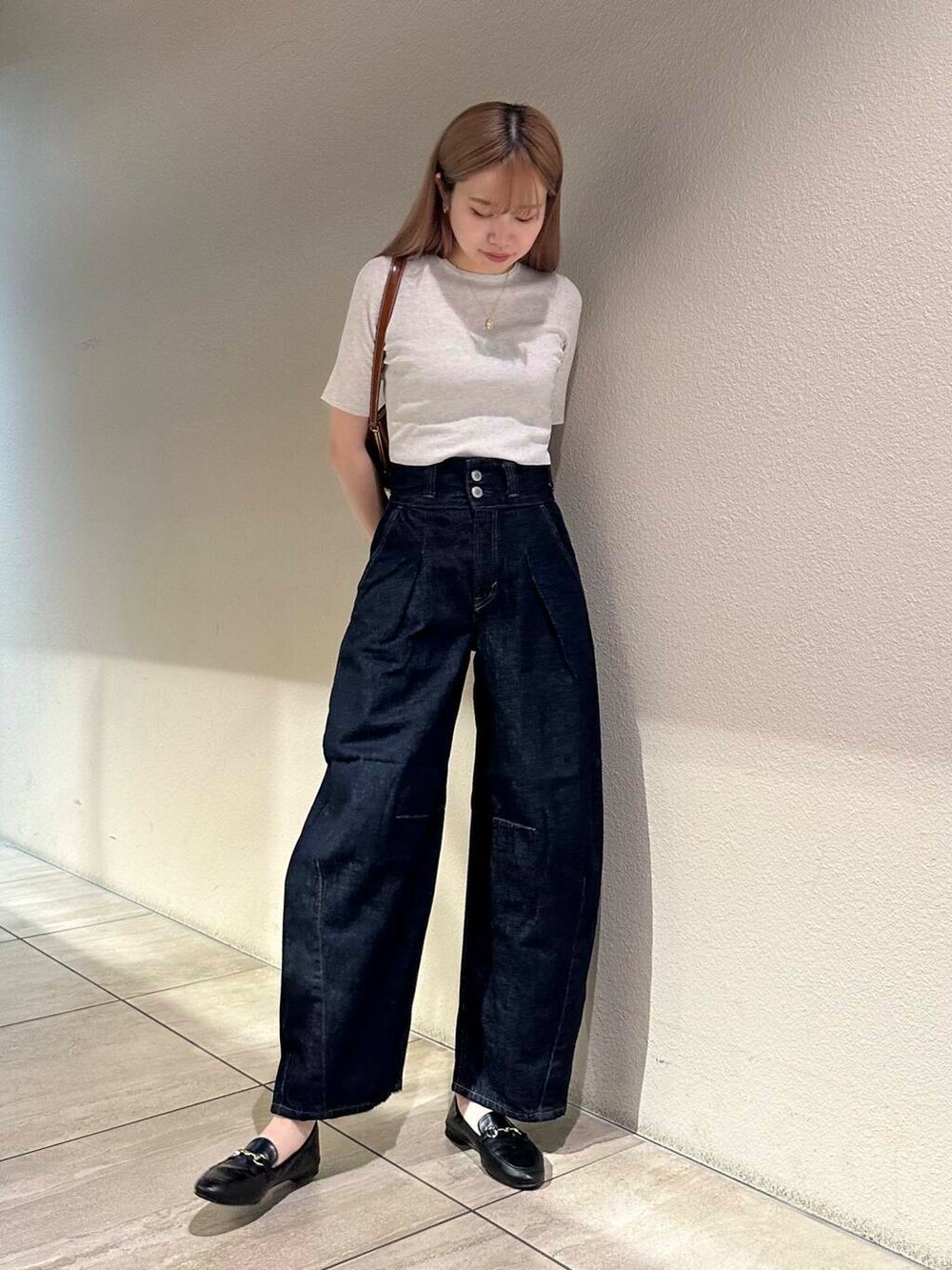 ブラック系のローファー、ホワイト系のニット/セーター、ブルー系のデニムパンツを着用したレディースの秋コーディネートの5枚目の写真