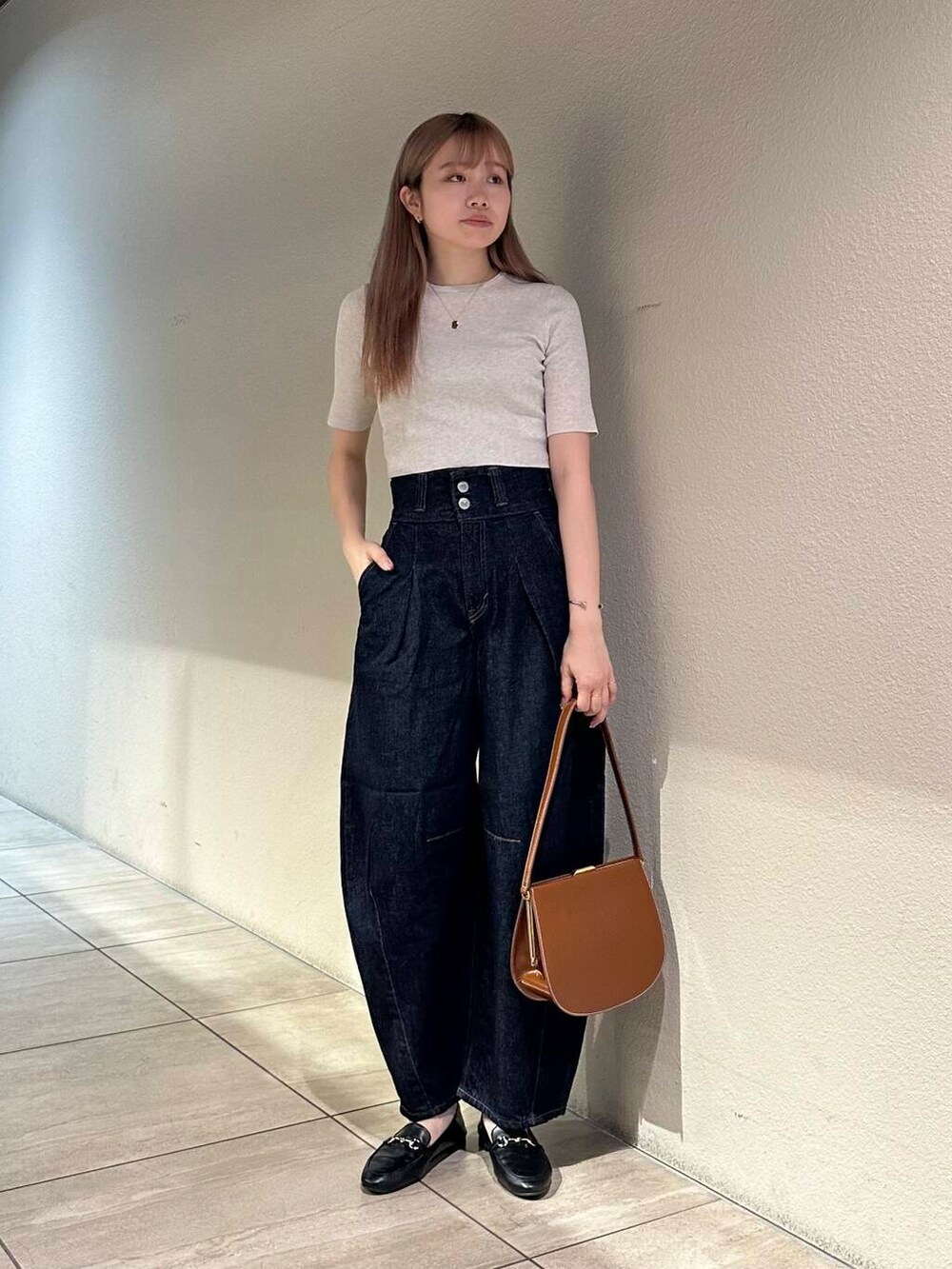 ブラック系のローファー、ホワイト系のニット/セーター、ブルー系のデニムパンツを着用したレディースの秋コーディネートの4枚目の写真