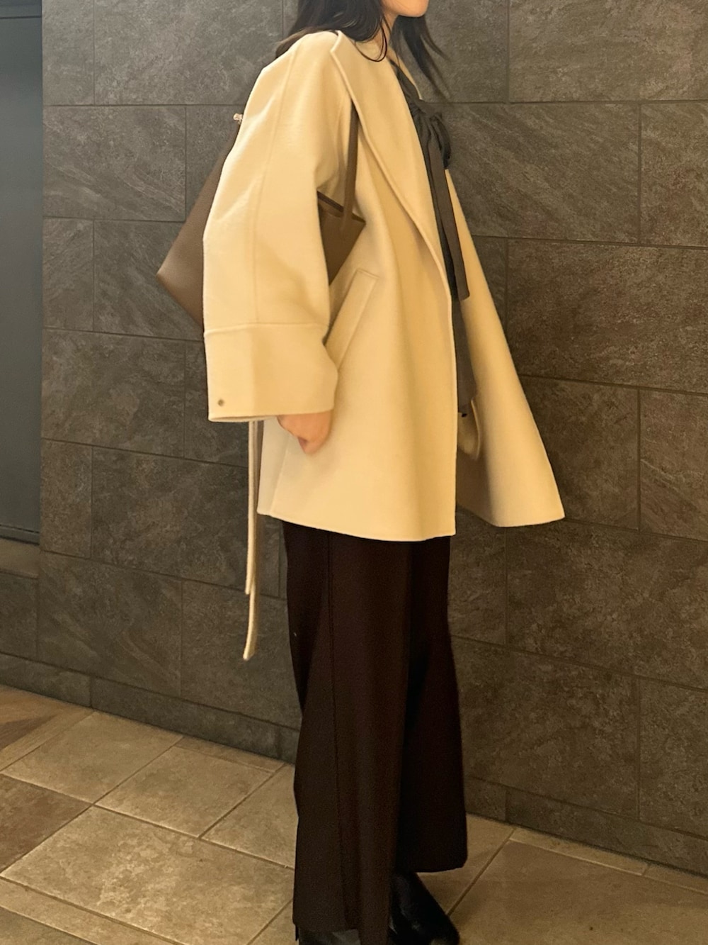 グレー系のシャツ/ブラウス、ブラウン系のその他パンツ、ブラック系のブーツを着用したレディースの秋コーディネートの4枚目の写真