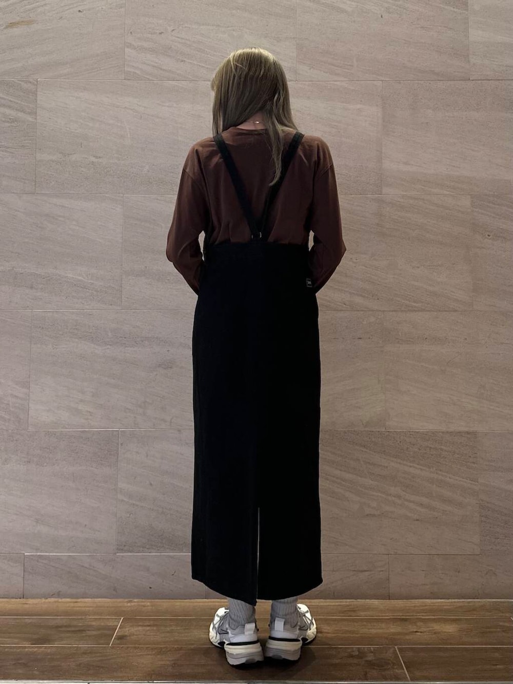 ブラック系のワンピース、ブラウン系のTシャツ/カットソー、ホワイト系のスニーカーを着用したレディースの冬コーディネートの4枚目の写真