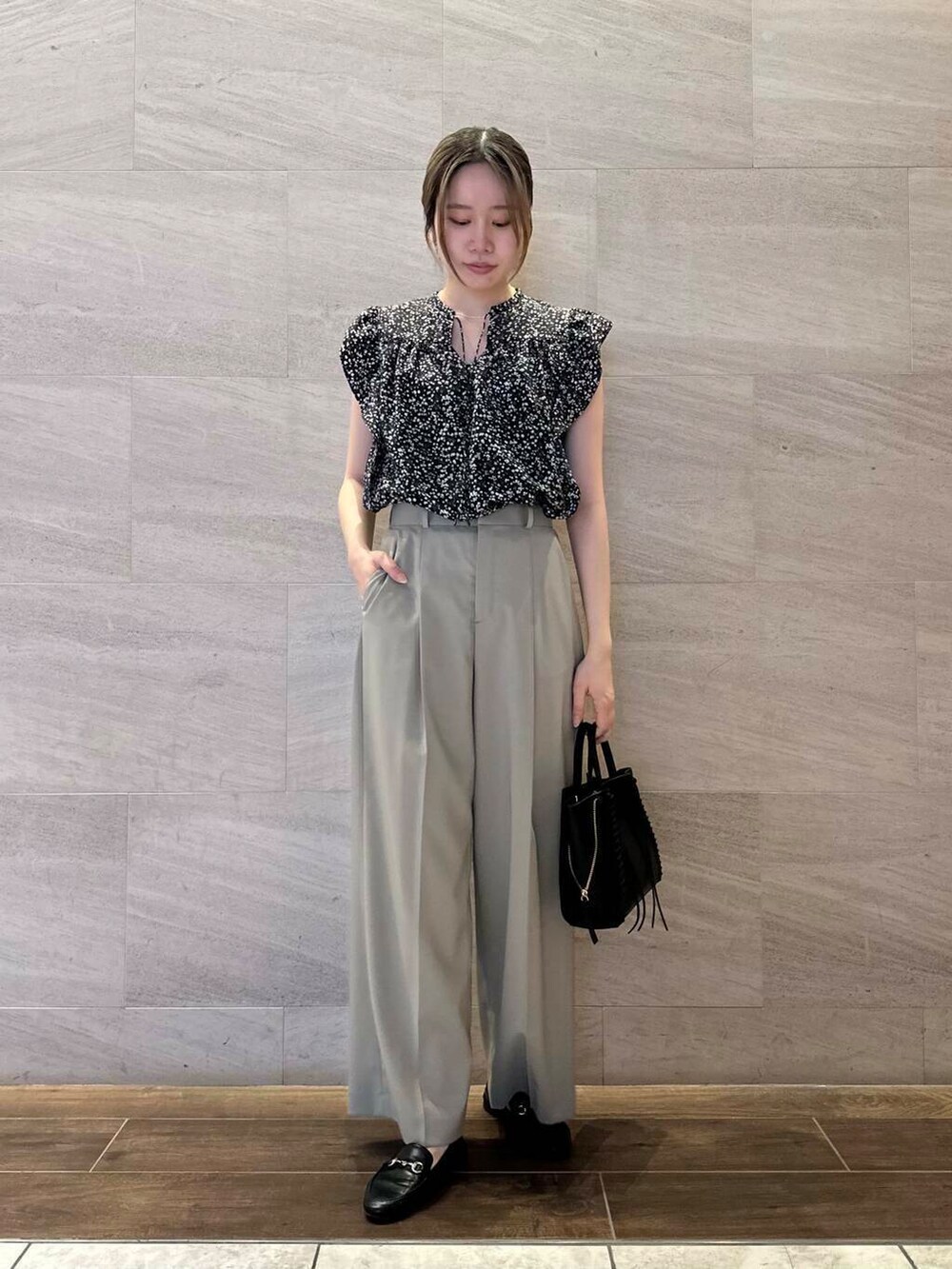 ブラウン系のその他パンツ、ブラック系のシャツ/ブラウス、ブラック系のショルダーバッグを着用したレディースの春コーディネートの2枚目の写真