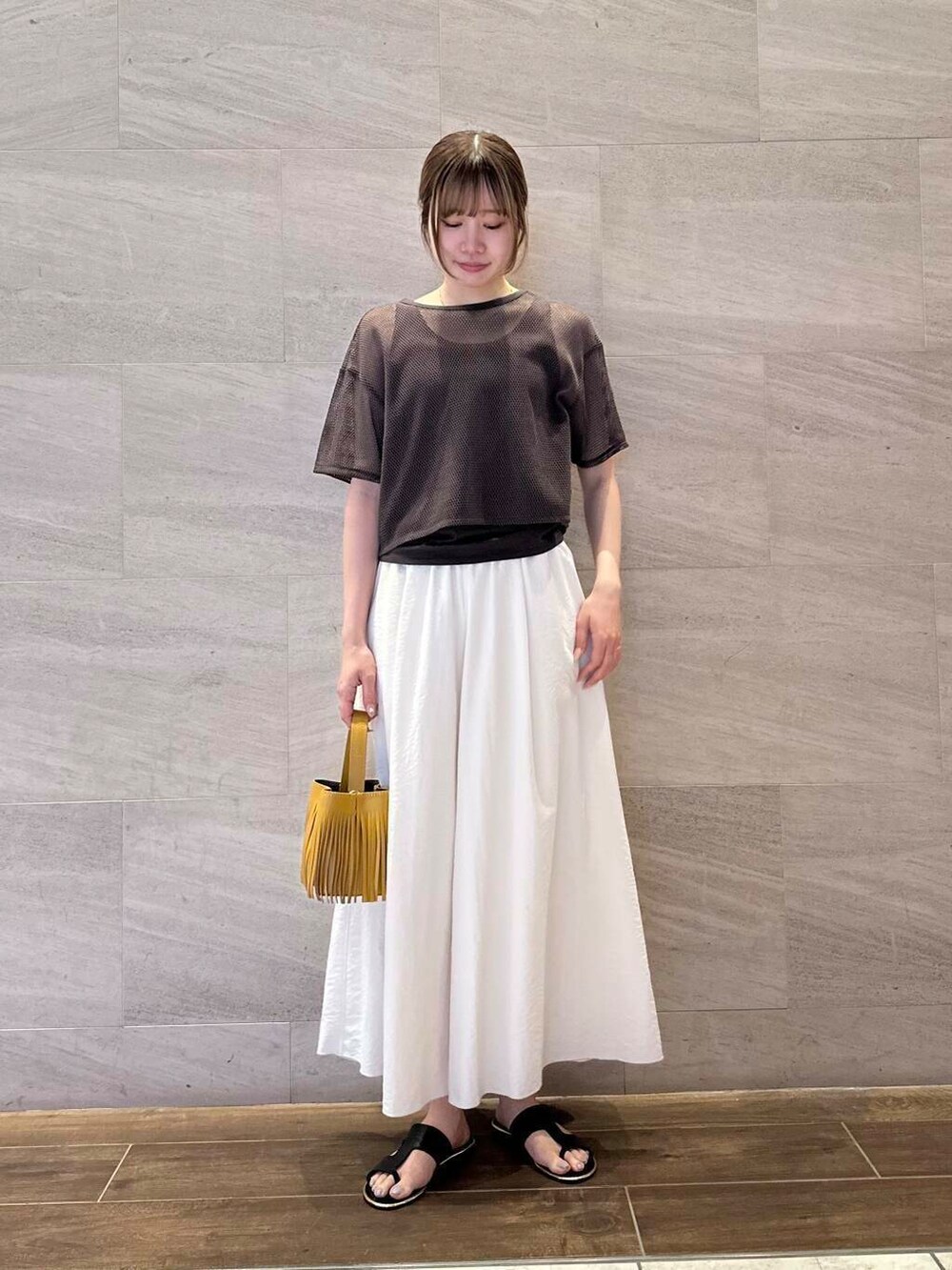 イエロー系のハンドバッグ、ホワイト系のその他パンツ、ブラウン系のTシャツ/カットソーを着用したレディースの夏コーディネートの5枚目の写真