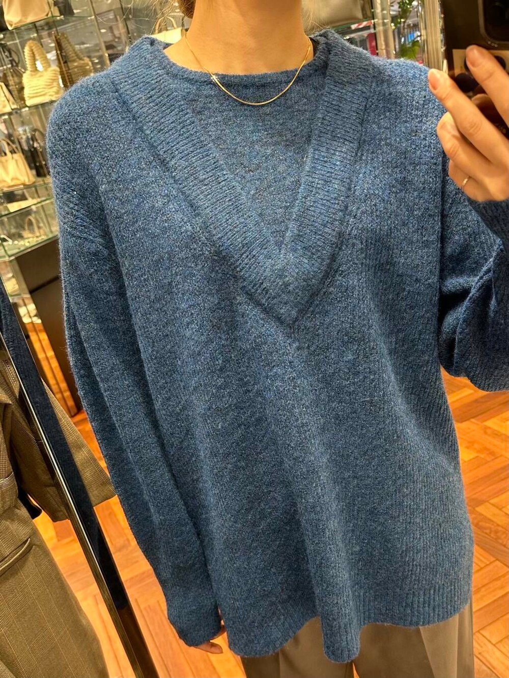 ブラック系のブーツ、ブラック系のハンドバッグ、グレー系のスカートを着用したレディースの冬コーディネートの6枚目の写真