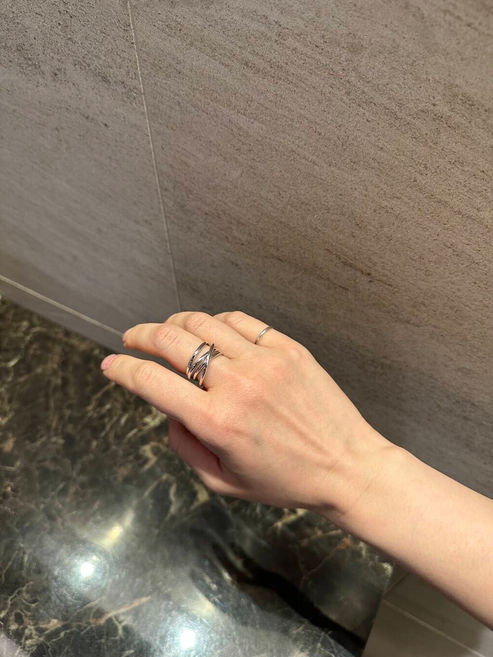 シルバー系のハンドバッグ、ブルー系のワンピース、シルバー系のリングを着用したレディースの夏コーディネートの5枚目の写真