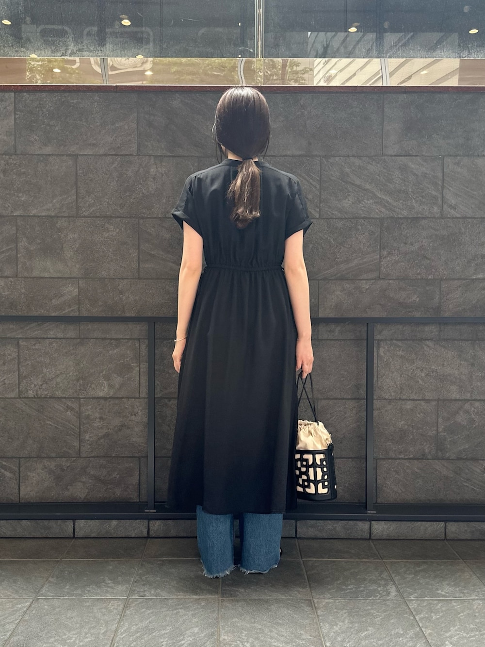 ブラック系のワンピース、ブラック系のショルダーバッグ、ブラウン系のサンダルを着用したレディースの春コーディネートの3枚目の写真