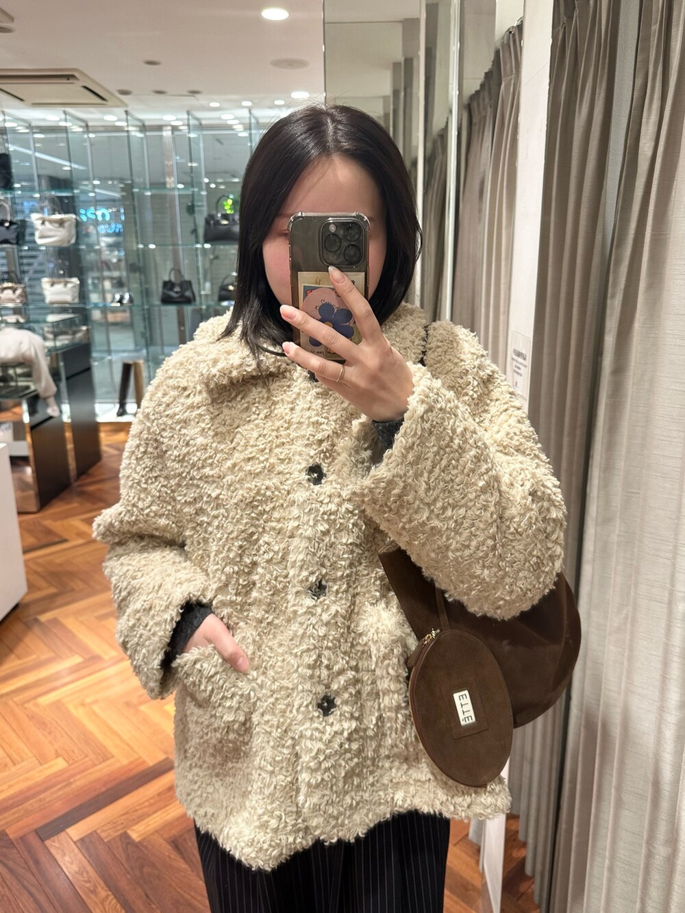 ホワイト系のその他アウター、ブラウン系のトートバッグ、その他のその他パンツを着用したレディースの冬コーディネートの4枚目の写真
