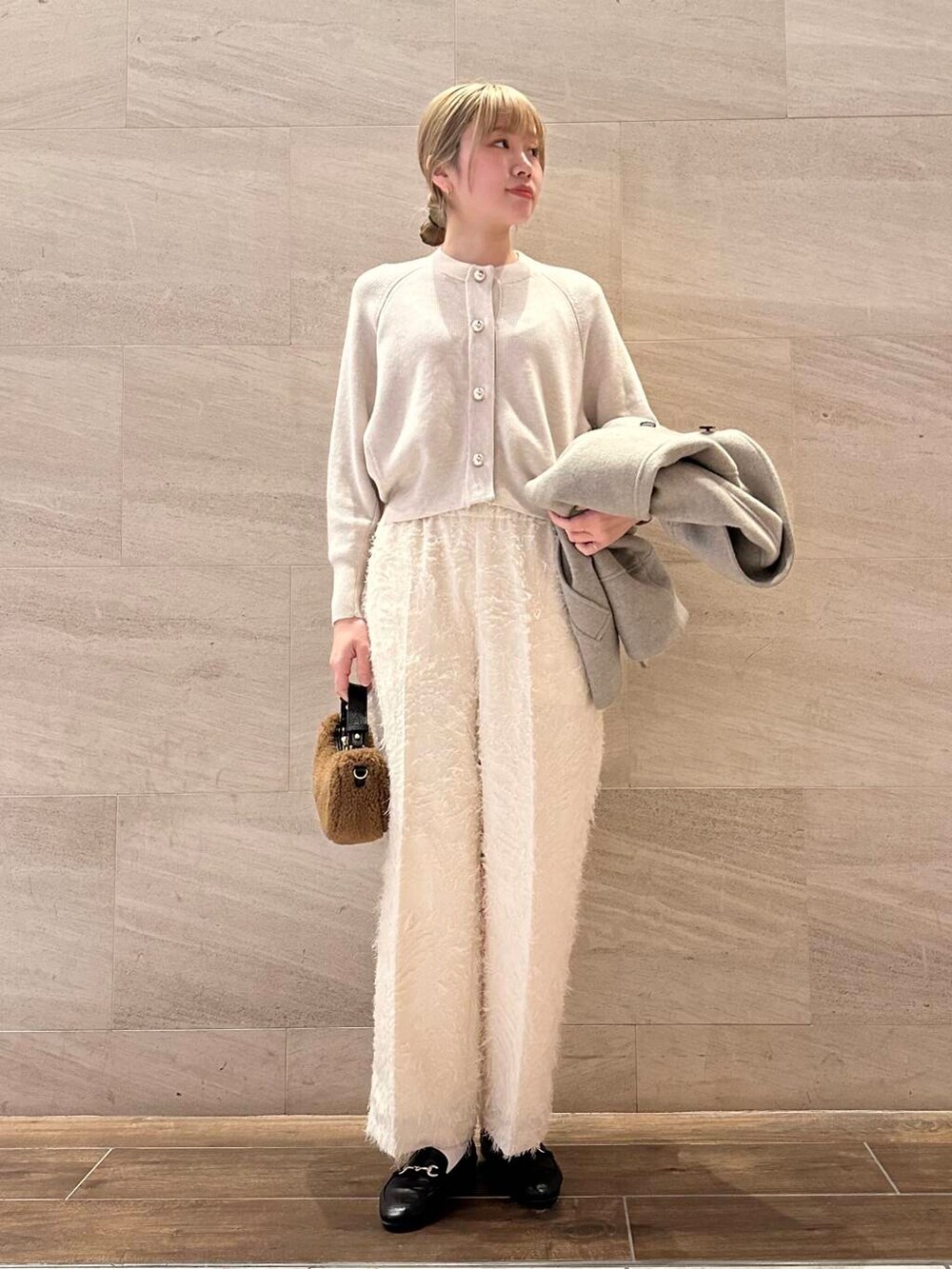 ブラウン系のピーコート、ホワイト系のその他パンツ、ホワイト系のカーディガン/ボレロを着用したレディースの冬コーディネートの6枚目の写真