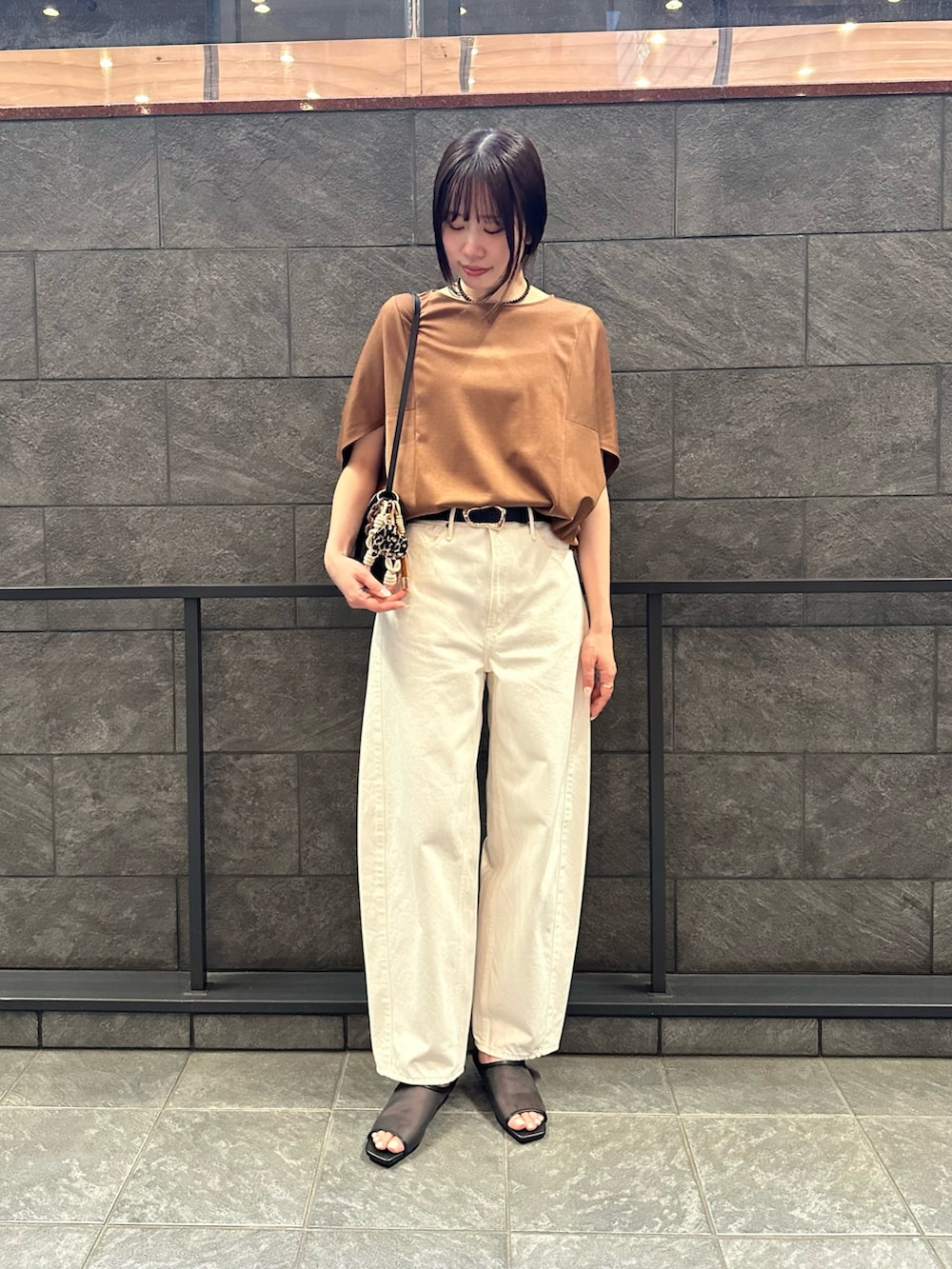 イエロー系のTシャツ/カットソー、ホワイト系のその他パンツ、ブラック系のサンダルを着用したレディースの夏コーディネートの2枚目の写真