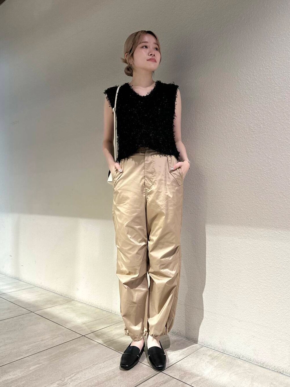 ブラック系のローファー、ホワイト系のショルダーバッグ、ベージュ系のその他パンツを着用したレディースの秋コーディネートの4枚目の写真