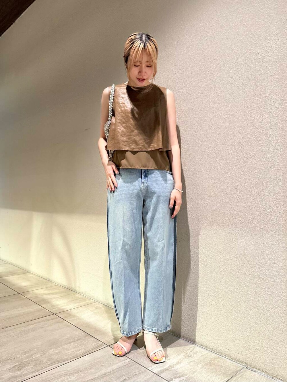 ホワイト系のサンダル、ブラウン系のシャツ/ブラウス、ブルー系のデニムパンツを着用したレディースの夏コーディネートの2枚目の写真