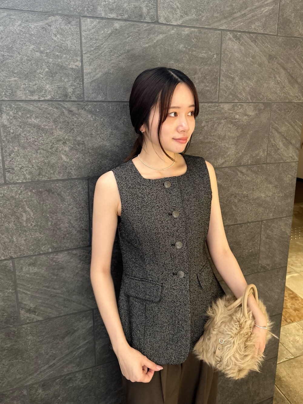 ブラック系のベスト、イエロー系のハンドバッグ、ブラウン系のその他パンツを着用したレディースの夏コーディネートの5枚目の写真