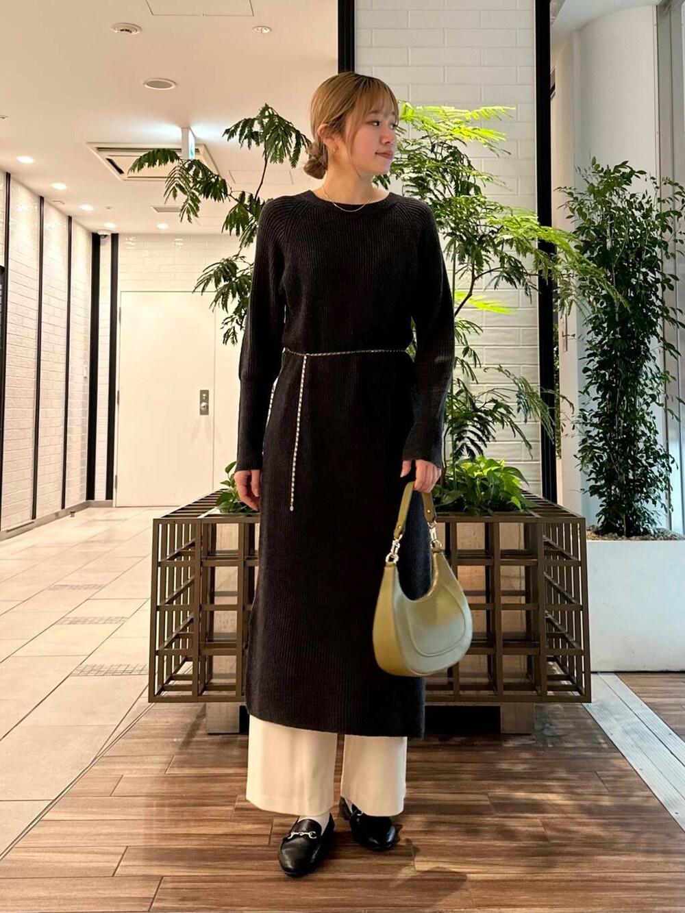 グリーン系のショルダーバッグ、グレー系のワンピース、ホワイト系のその他パンツを着用したレディースの冬コーディネートの2枚目の写真