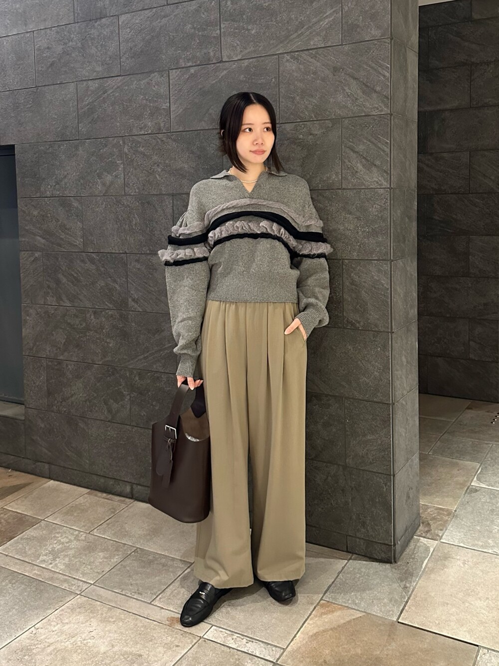 ブラウン系のショルダーバッグ、ベージュ系のその他パンツ、グレー系のニット/セーターを着用したレディースの秋コーディネートの3枚目の写真